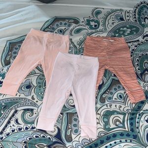 3 different pink pairs of leggings, two are plain and one has white stripes.